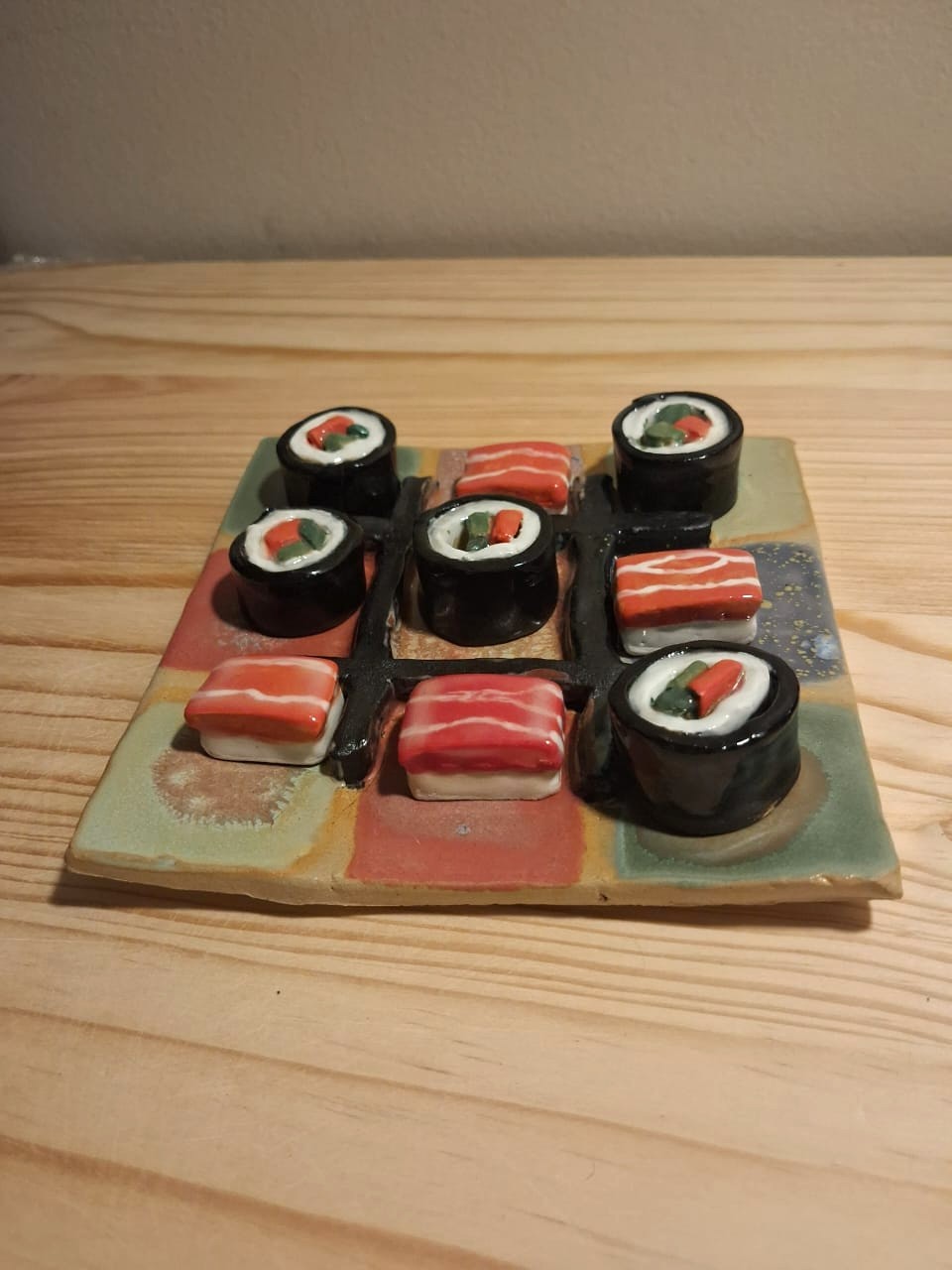 Noughts and crosses board with sushi pieces by Amy - pottery class student
